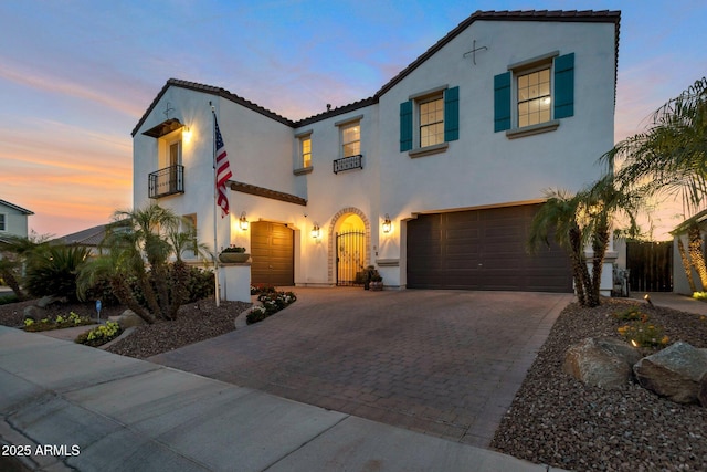 9608 N 184th Ln, Waddell, AZ 85355 - mediterranean / spanish home featuring a balcony, an attached garage, stucco siding, decorative driveway, and a tiled roof
