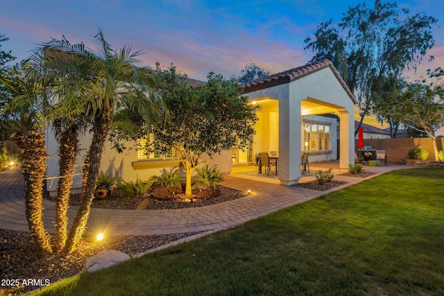 9608 N 184th Ln, Waddell, AZ 85355 - back of property at dusk with stucco siding, a patio, and a tiled roof