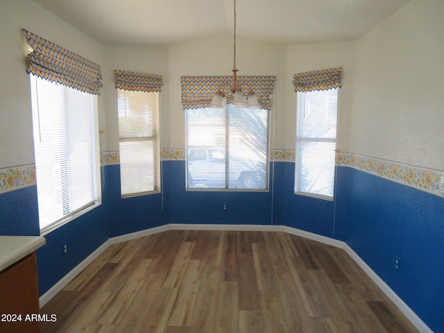 unfurnished dining area with vaulted ceiling, dark wood-type flooring, and a wealth of natural light