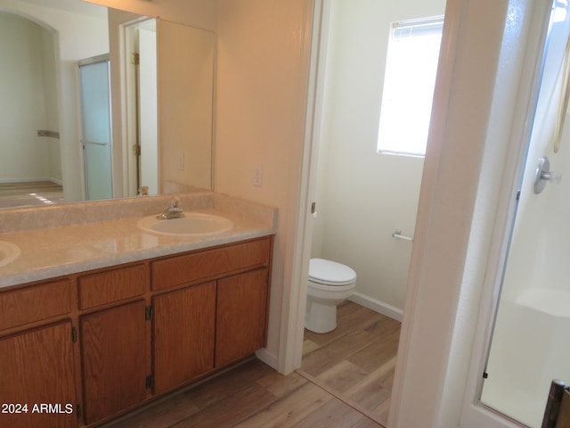 bathroom featuring wood-type flooring, vanity, and toilet