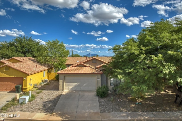 mediterranean / spanish-style home with cooling unit and a garage