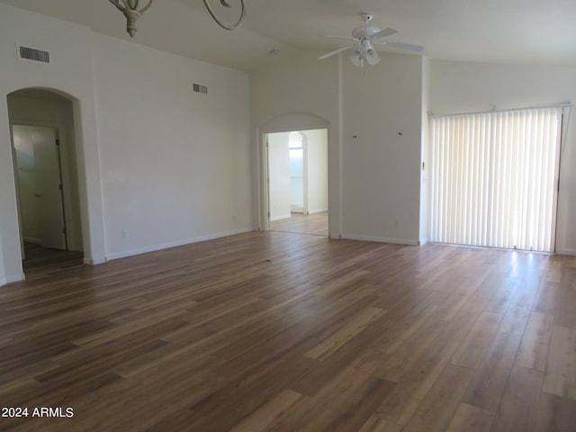 empty room featuring dark hardwood / wood-style flooring, ceiling fan, and high vaulted ceiling