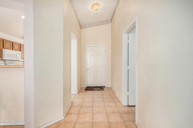 corridor with light tile patterned floors and high vaulted ceiling