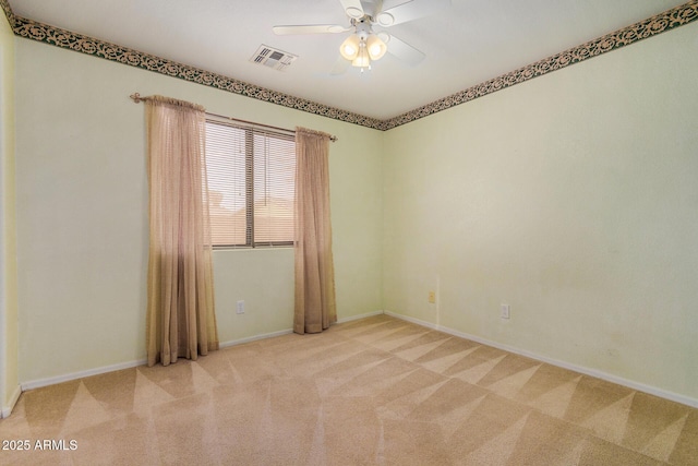 unfurnished room featuring light colored carpet and ceiling fan