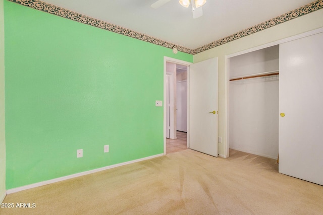 unfurnished bedroom featuring ceiling fan, light colored carpet, and a closet