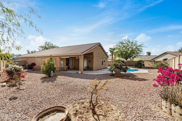 back of house featuring a fenced in pool and a patio area