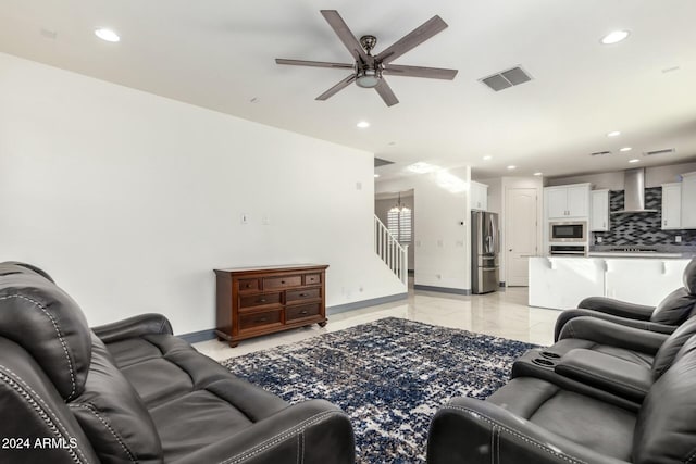 living room with ceiling fan with notable chandelier