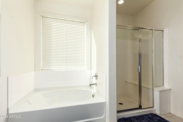 bathroom with tile patterned flooring and separate shower and tub