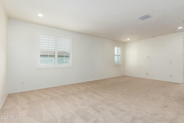 unfurnished room featuring light carpet