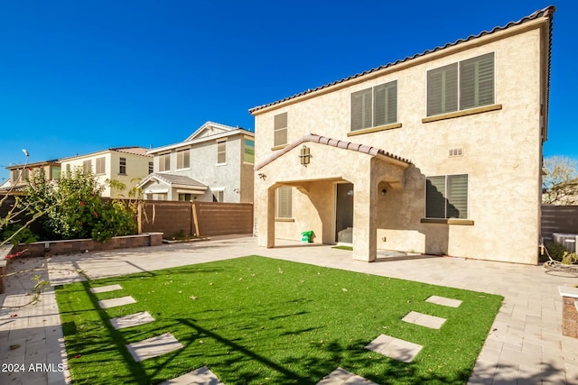 back of property featuring a lawn and a patio area