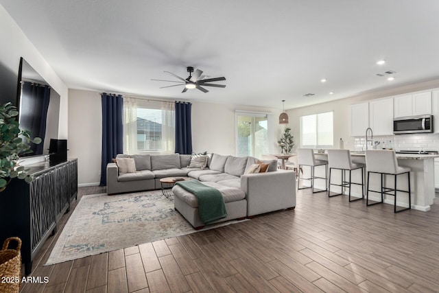 living room with ceiling fan and plenty of natural light