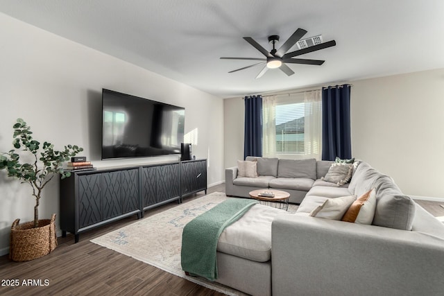 living room featuring ceiling fan and dark wood-type flooring