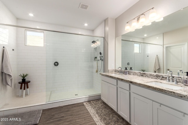 bathroom featuring walk in shower and vanity