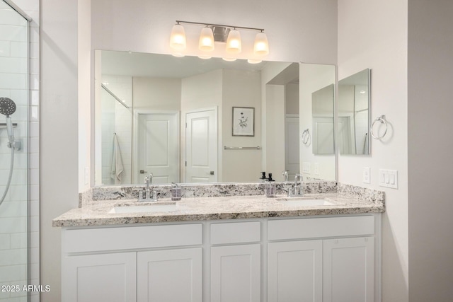 bathroom featuring a shower with door and vanity