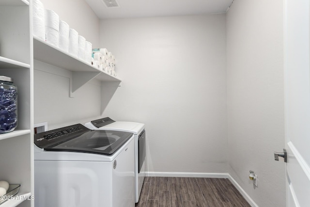 washroom with dark wood-type flooring and washer and clothes dryer