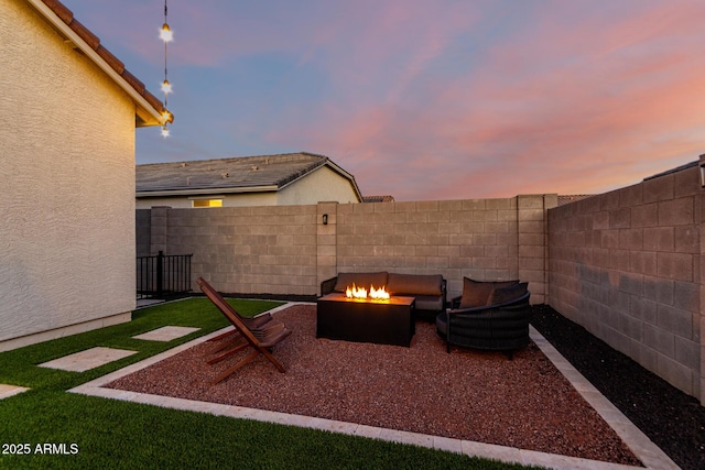 patio terrace at dusk featuring an outdoor fire pit