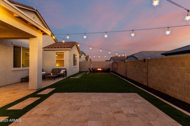 yard at dusk featuring a patio and outdoor lounge area