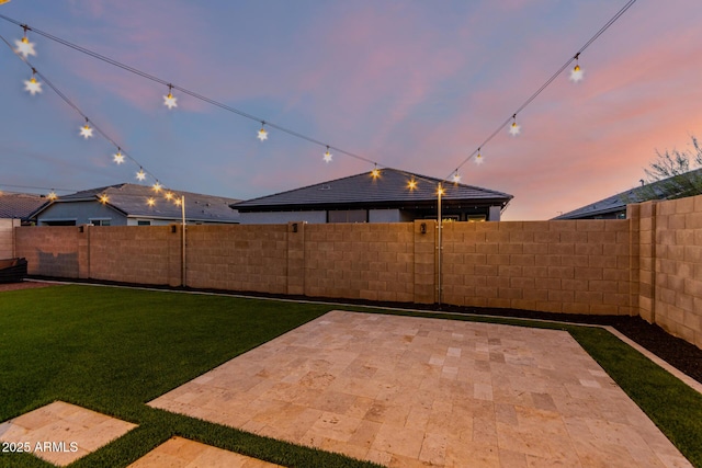 yard at dusk featuring a patio