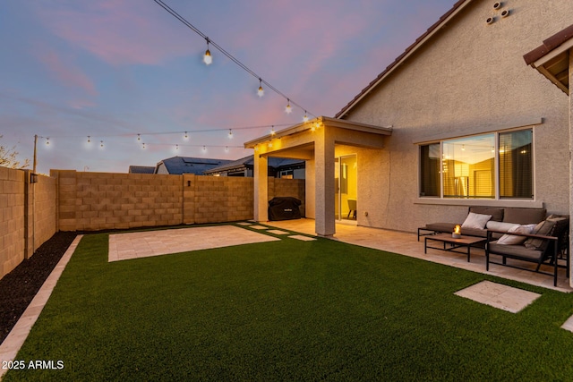 yard at dusk featuring outdoor lounge area and a patio