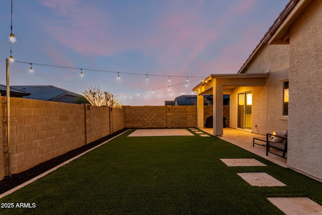 yard at dusk with a patio area