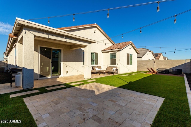 back of property with a yard and a patio