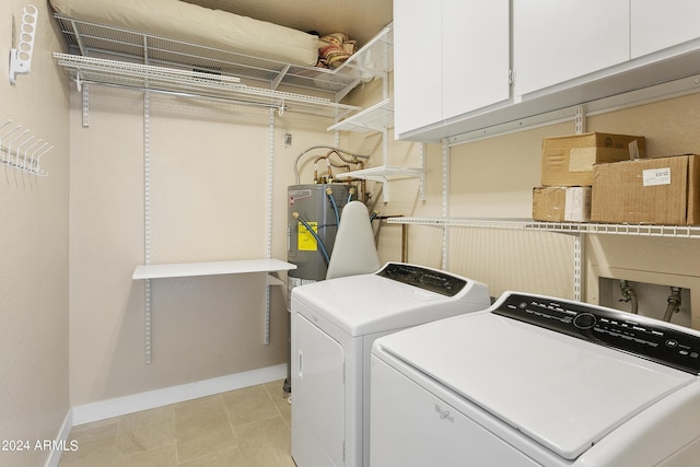 laundry room featuring cabinets, independent washer and dryer, and electric water heater