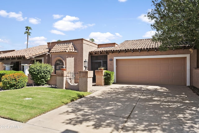 mediterranean / spanish house featuring a garage and a front lawn