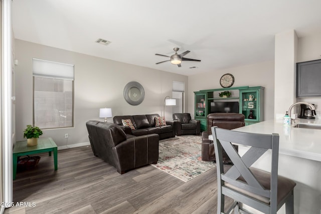 living room featuring sink, hardwood / wood-style floors, and ceiling fan