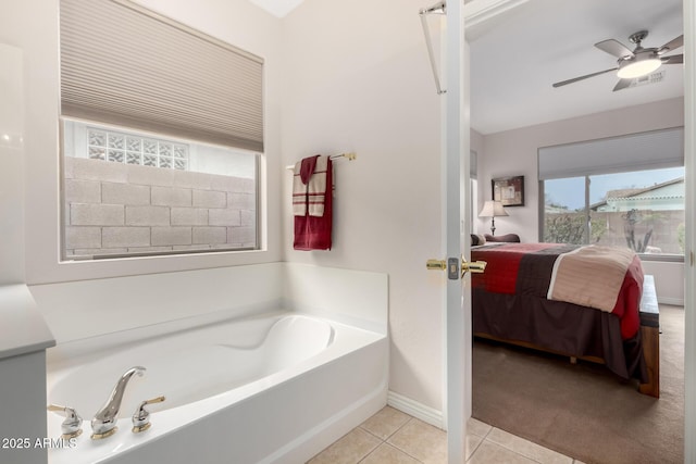 bathroom with ceiling fan, tile patterned floors, and a bathing tub