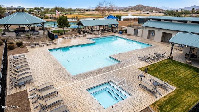 view of pool with a hot tub, a gazebo, a water and mountain view, and a patio area