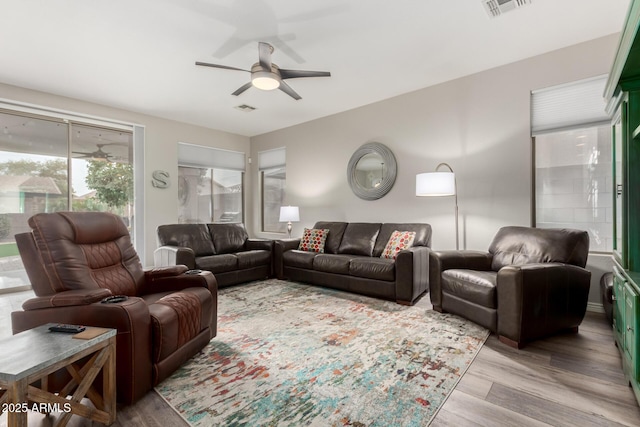 living room with light hardwood / wood-style flooring and ceiling fan