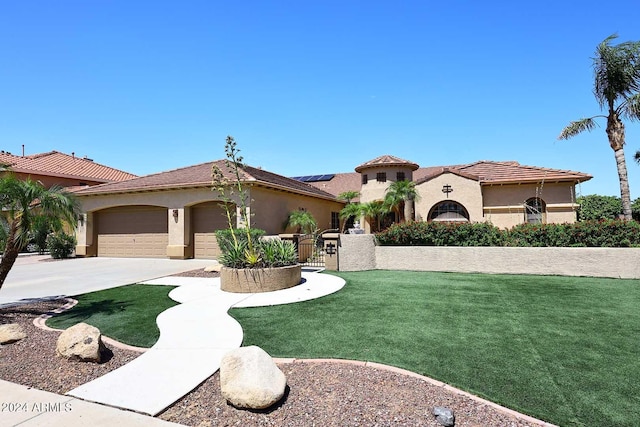 mediterranean / spanish home featuring a garage and a front yard