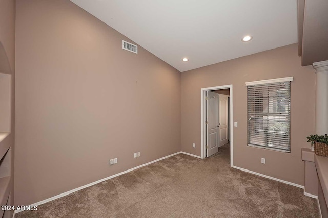 unfurnished bedroom with carpet floors and vaulted ceiling