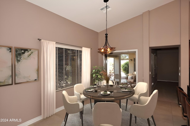 dining space featuring high vaulted ceiling