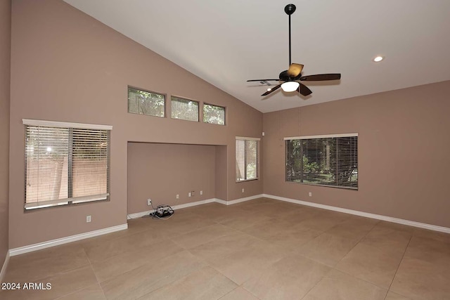 tiled empty room with ceiling fan and high vaulted ceiling