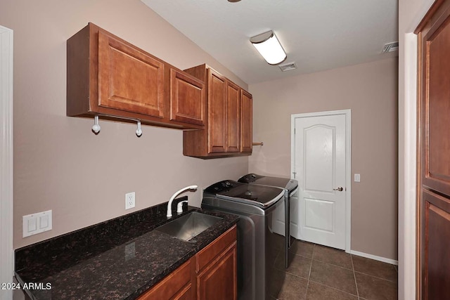 laundry room featuring dark tile patterned flooring, cabinets, independent washer and dryer, and sink