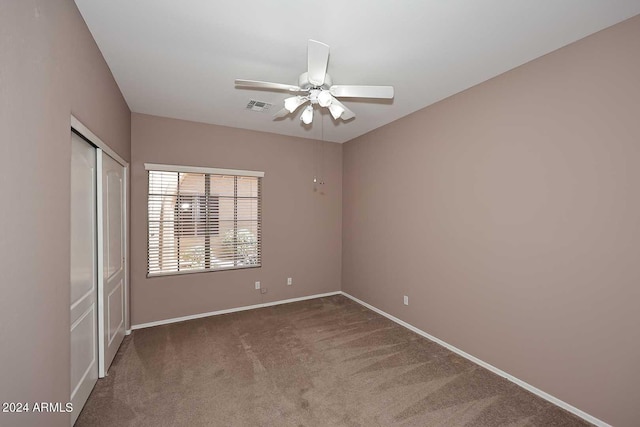 carpeted spare room with ceiling fan