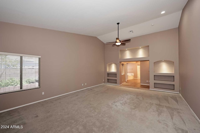 unfurnished living room with built in shelves, light colored carpet, ceiling fan, and lofted ceiling