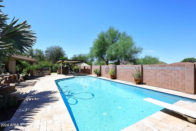 view of swimming pool with a diving board