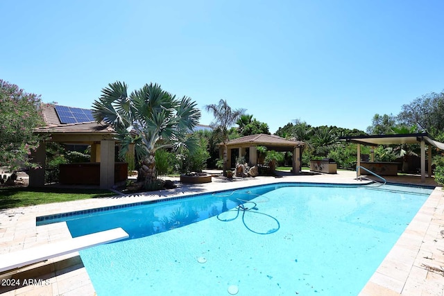 view of swimming pool featuring a gazebo and a diving board