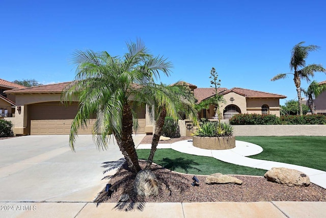 mediterranean / spanish-style house with a front yard and a garage