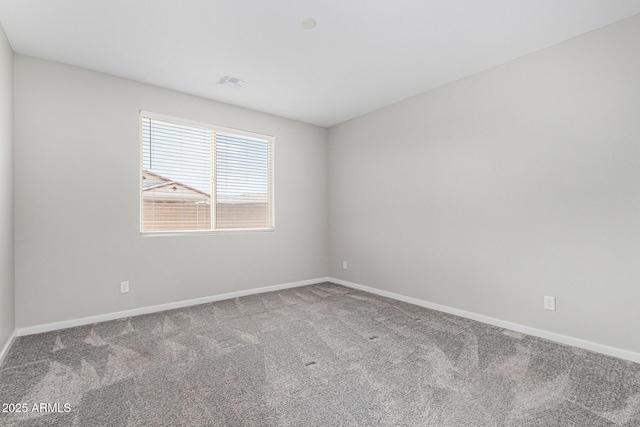 carpeted spare room with visible vents and baseboards