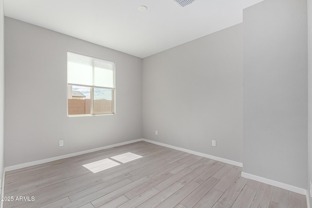 unfurnished room with baseboards and light wood-style flooring