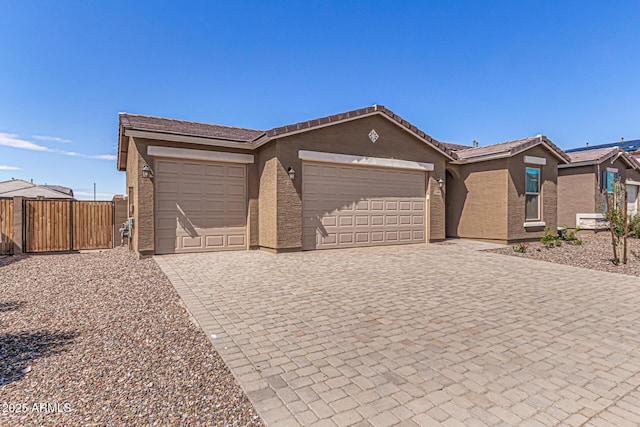 single story home with fence, stucco siding, a garage, a tiled roof, and decorative driveway