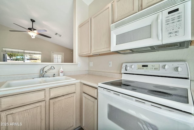 kitchen featuring vaulted ceiling, light brown cabinetry, sink, and white appliances