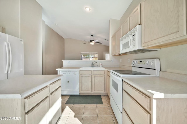 kitchen featuring white appliances, vaulted ceiling, light brown cabinetry, sink, and light tile patterned flooring