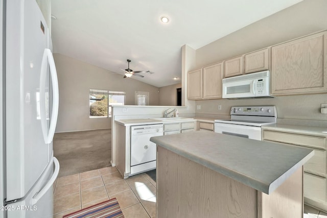 kitchen with lofted ceiling, a center island, white appliances, light brown cabinets, and light carpet