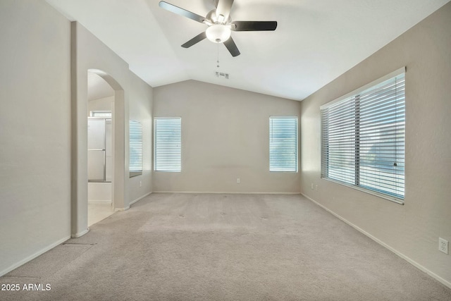 empty room with vaulted ceiling, ceiling fan, and light carpet