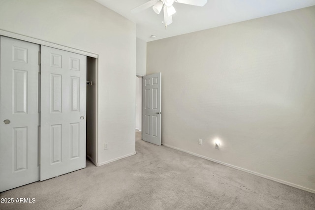 unfurnished bedroom featuring ceiling fan, a closet, and light colored carpet