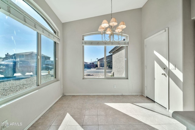 unfurnished dining area featuring light tile patterned floors, vaulted ceiling, an inviting chandelier, and a healthy amount of sunlight